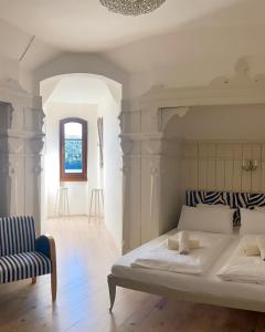 米爾施塔特的住宿－施特萊恩茨別墅酒店，一间卧室配有一张大床和一把椅子