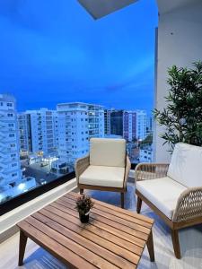 a balcony with a table and chairs and a view of a city at Downtown Santo Domingo Luxury Apartment in Santo Domingo