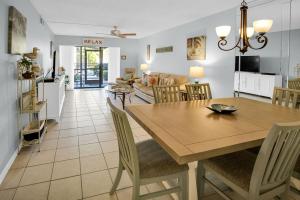a dining room and living room with a table and chairs at Siesta Key Escape Ground Floor Steps to Heated Pool and Free Trolley in Siesta Key