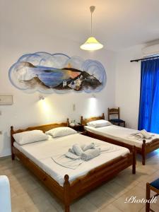 2 camas en una habitación con un cuadro en la pared en Santa Barbara, en Perissa