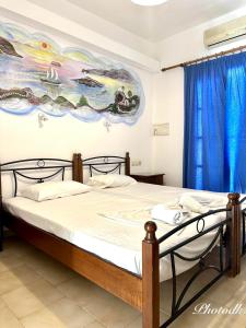 a bedroom with a bed with a painting on the wall at Santa Barbara in Perissa