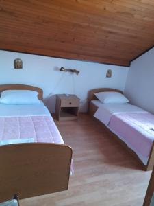 two beds in a room with wooden ceilings at MIR in Međugorje +40 photos