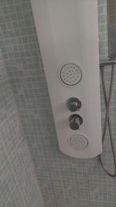 a shower in a bathroom with two knobs on the wall at Villa Machilly in Machilly