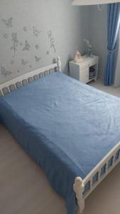 ein Schlafzimmer mit einem Bett mit einer blauen Decke in der Unterkunft Villa Machilly in Machilly