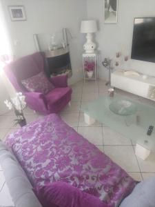 ein Wohnzimmer mit einem lila Sofa und einem Tisch in der Unterkunft Villa Machilly in Machilly