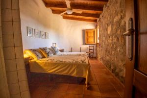 een slaapkamer met een bed in een kamer met een stenen muur bij Casa Mimosa in Candeleda