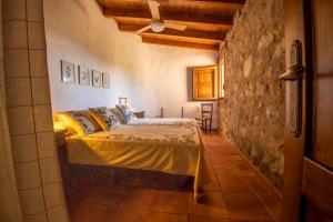 a bedroom with a bed in a room with a stone wall at Casa Mimosa in Candeleda +16 photos
