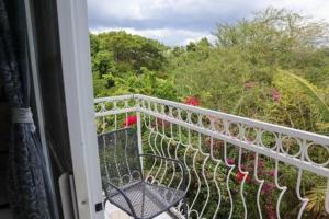a balcony with a bench and a view of a garden at Kokojo Villa in Black River
