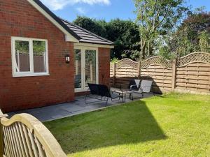 a patio with chairs and a fence in a yard at Beautiful Holiday Cottage in Ashbourne