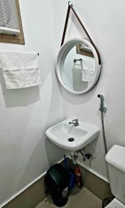 uma casa de banho branca com um lavatório e um espelho em Cassie Homestay - Yuna Door 2 - Furnished Home in Butuan em Butuan