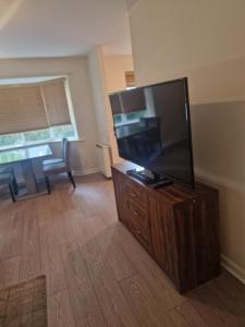sala de estar con TV de pantalla plana en un centro de entretenimiento de madera en 2 Bed 2 Bath Ensuite - FREE secure parking en Birmingham