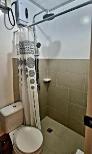 a small bathroom with a toilet and a shower at Cassie Homestay - Yuna Door 2 - Furnished Home in Butuan in Butuan