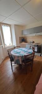 - une cuisine avec une table et des chaises dans la chambre dans l'établissement Appartement Douillet, à Saint-Maixent-lʼÉcole