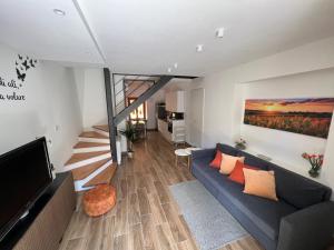 un soggiorno con divano blu e scala di Appartamento Il Poggetto a Montefiascone