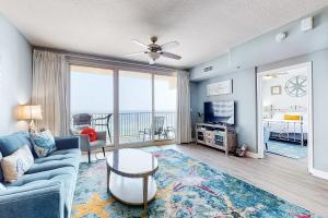 a living room with a blue couch and a tv at Shores of Panama III in Panama City Beach