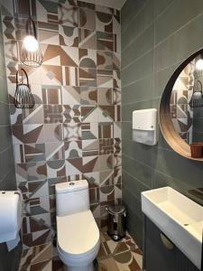 a bathroom with a toilet and a sink and a mirror at Downtown Santo Domingo Luxury Apartment in Santo Domingo