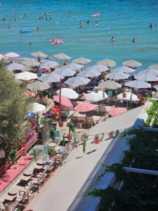 a beach with umbrellas and people in the water at Studio Just On The Beach in Paralia Katerinis