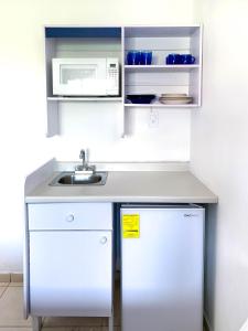 uma cozinha branca com um lavatório e um micro-ondas em La Casa del Expositor em Guadalajara