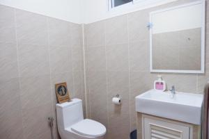 een badkamer met een toilet, een wastafel en een spiegel bij Khao Sok Hill Top Resort in Khao Sok
