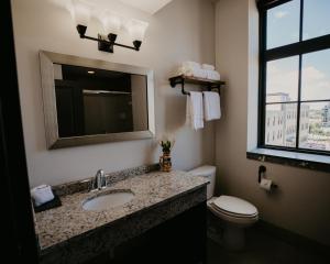 a bathroom with a sink and a toilet and a mirror at Brewhouse Inn and Suites in Milwaukee