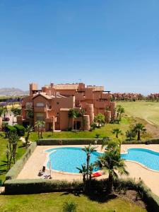 - Vistas a una casa con 2 piscinas en Zeer trendy 2-bed penthouse op de Mar Menor Golf & Padel Resort, en Torre-Pacheco