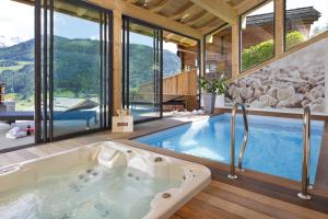 a bathroom with a tub and a swimming pool at Chalet Marin in Le Grand-Bornand