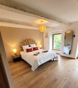 1 dormitorio con cama grande y ventana grande en La Maison d'Equilly en Équilly