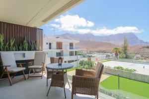 balcón con mesa, sillas y vistas en Agaete Sunset Vista with jacuzzi 2-BR Apartment, en Puerto de las Nieves