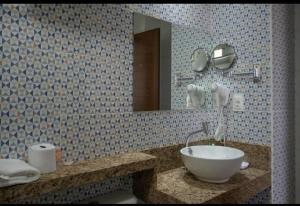 a bathroom with a sink and a mirror at EMA HOTEL in Serra Talhada