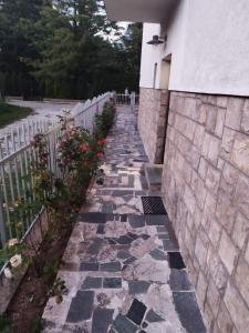 a stone walkway next to a building with a fence at Villa Amer Lux Apartments in Sarajevo