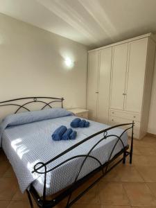sypialnia z łóżkiem z dwoma niebieskimi ręcznikami w obiekcie Veliero House w mieście Murta Maria