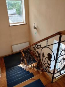 een trap met een smeedijzeren leuning en een raam bij Готель Стефанія in Romny