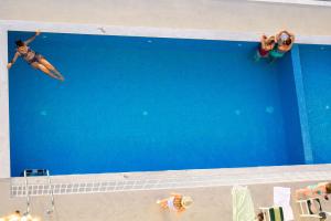 una persona en una tabla de surf en una piscina en Hotel Vola, en Sarandë