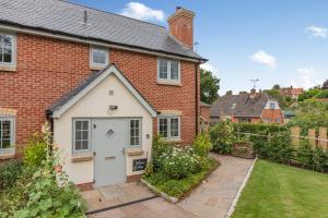 a red brick house with a white garage at Buttercup Cottage in Salisbury