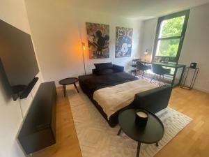 um quarto com uma cama, uma mesa e uma televisão em V & S Apartments Since 2023 em Düsseldorf