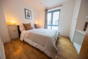 a bedroom with a bed and a large window at Apartment by Spitalfields & Liverpool Street Station in London