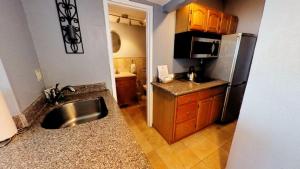 a kitchen with a sink and a stainless steel refrigerator at Castle 828 Oceanfront view with balcony, pool, tennis, beach access and free parking! in Miami Beach +29 photos