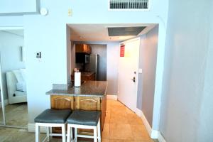 a kitchen with a counter and two stools at Oceanfront views, balcony & gym, bars, beach access and free parking! in Miami Beach