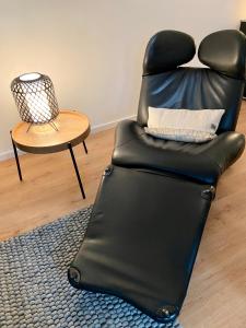 a black reclining chair in a living room with a table at Harzpur Lodge - Pure Entspannung in purer Natur in Hahnenklee-Bockswiese