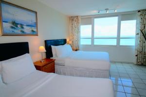 A bed or beds in a room at Castle 1733 Ocean view studio with direct beach access, pool, tennis & free parking