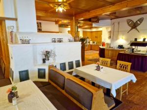 uma sala de jantar com duas mesas e uma cozinha em Das Alpin - Hotel Garni Guesthouse em Scheffau am Wilden Kaiser