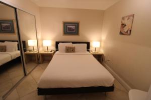 a hotel room with a bed and two mirrors at Castle B17 Contemporary Condo with Pool, Beach Access and Free Parking in Miami Beach
