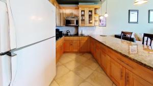 a kitchen with a white refrigerator and wooden cabinets at Castle B17 Contemporary Condo with Pool, Beach Access and Free Parking in Miami Beach +64 photos