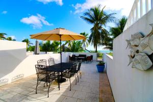 a patio with a table and chairs and an umbrella at Oceanfront Townhouse with direct access to the Beach! Steps from the sand! in Miami Beach