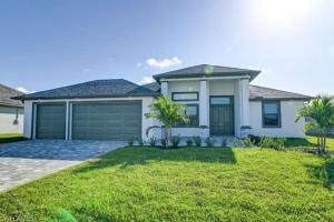 una gran casa blanca con garaje en Newly built Villa Ballerina with heated pool and incredible view into beautiful Arrowheadcanal en Cape Coral