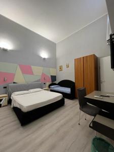 1 dormitorio con 2 camas, escritorio y TV en Gemy, en Boissano