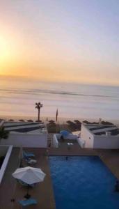 Sidi BouqnadelにあるAppartements lux respectueuxのスイミングプールと海を望むリゾートです。