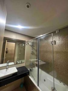 y baño con ducha acristalada y lavamanos. en Appartements lux respectueux en Sidi Bouqnadel