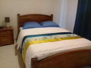 a bedroom with a bed with blue and yellow sheets at AU MEUBLE DURANTAS in Petite Île