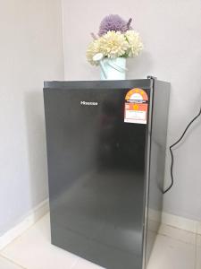 einen Kühlschrank mit einer Blumenvase darüber in der Unterkunft Homestay Machang - Lycaste Inn Muslim in Macang